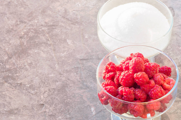 Glass of fresh raspberries and white sugar gardening gastronomy harvest summer evening sunset light Concept home made ingredient recipe for cooking jam and cookware - Fotó, kép