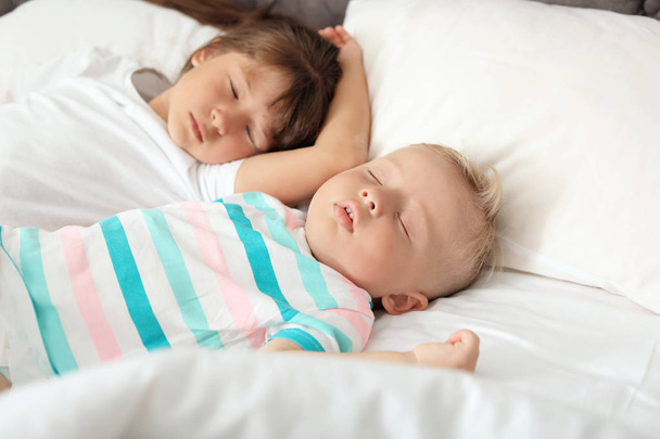 Little children sleeping in bed at home - 写真・画像