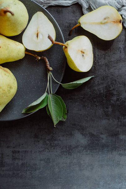 Ripe pears in a plate  on dark background - Foto, Imagem