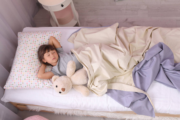 Mała dziewczynka, spanie w łóżku w domu - Zdjęcie, obraz