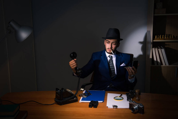Detektiv sitzt in dunklem Raum im Vintage-Konzept - Foto, Bild
