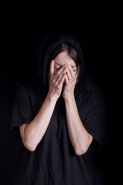 黒い服の女性は悲しみで目を閉じる - 写真・画像