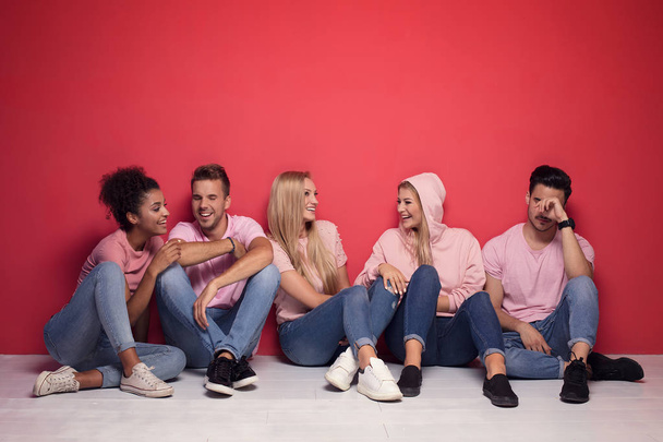 Young multi-ethnic attractive people smiling and spending time together, posing on colorful background. - Valokuva, kuva