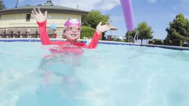 Pieni tyttö hauskaa uinti ulkouima-altaassa kesällä - Materiaali, video