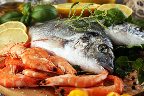 Delicious fresh fish. Fish with aromatic herbs, spices and vegetables - healthy food, diet or cooking concept - Photo, Image