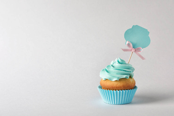 Delicious birthday cupcake and space for text on gray background - Photo, Image
