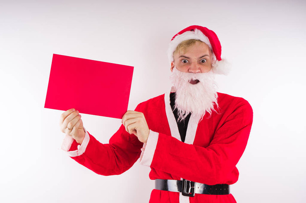 Santa Claus con un cartel sobre un fondo blanco. El concepto de descuentos y ventas para Navidad. Espacio vacío para texto
      - Foto, imagen