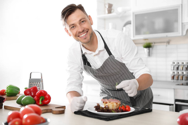 Professional chef presenting dish on table in kitchen - Foto, Imagem