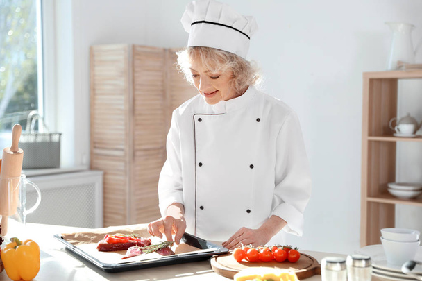Professional female chef preparing meat in kitchen - Valokuva, kuva
