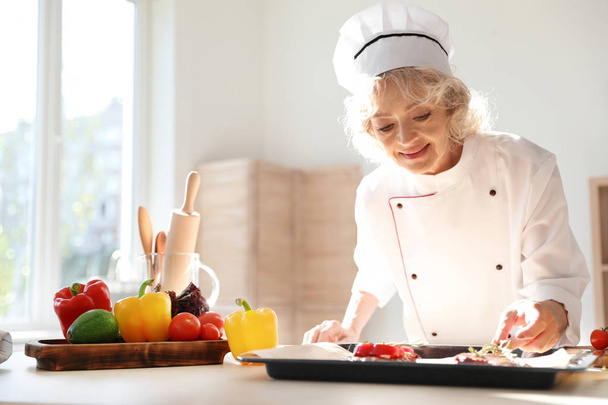 Professional female chef preparing meat in kitchen - Zdjęcie, obraz