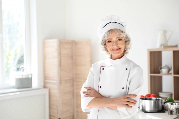 Professional female chef wearing uniform in kitchen - Fotó, kép