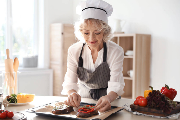 Professional female chef preparing meat on table in kitchen - Foto, immagini