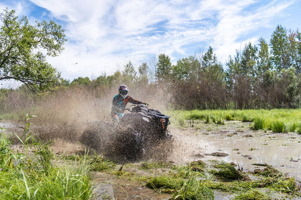 ATV Quad jezdí rychle na velké nečistoty a dělá postříkání špinavé vody - Fotografie, Obrázek