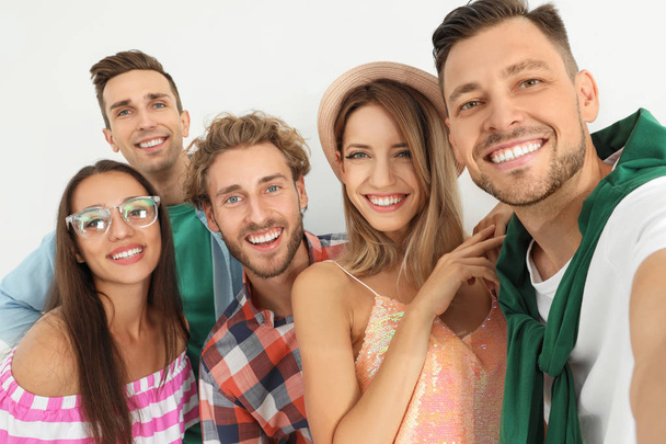Grupo de jóvenes felices tomando selfie sobre fondo blanco
 - Foto, Imagen