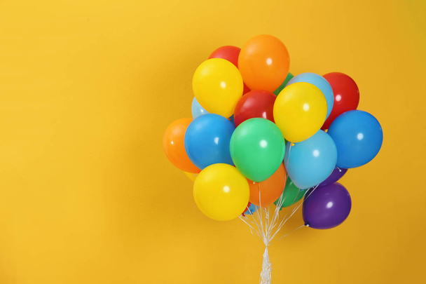 Bunch of bright balloons and space for text against color background - Fotoğraf, Görsel