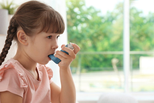 Little girl using asthma inhaler on blurred background - Fotografie, Obrázek