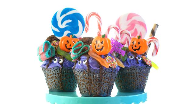 Halloween candyland drip cake style cupcakes with lollipops and candy on white. - Photo, Image