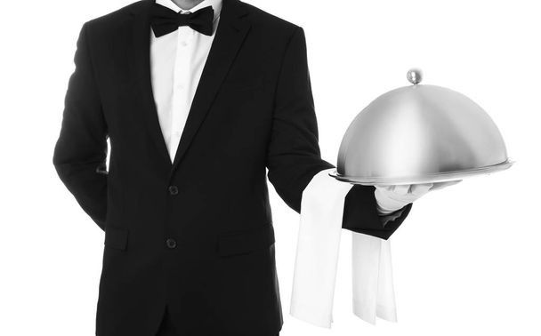 Waiter holding metal tray with lid on white background, closeup - Fotó, kép