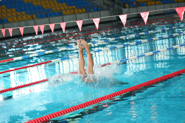 Young athletic man jumping into swimming pool - Foto, Bild