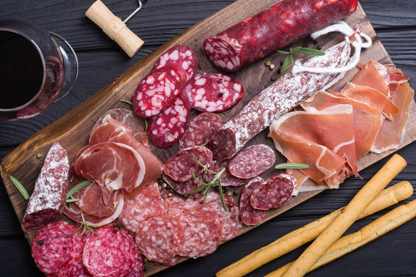 Assortment of sausages . Ham , salami and jamon on wooden board  - Фото, изображение