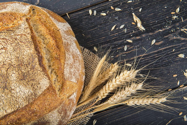 Bochenek chleba w domu sourdouhg, ozdobione płótnie i ziarna zbóż i uszy - Zdjęcie, obraz