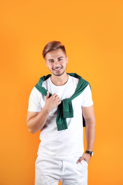 Young man with trendy hairstyle on color background - 写真・画像