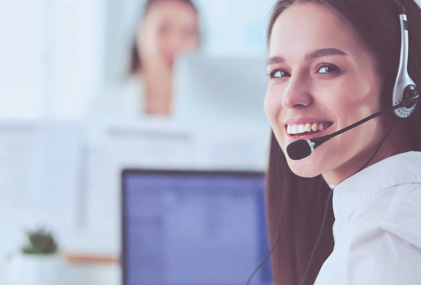 Smiling businesswoman or helpline operator with headset and computer at office - Foto, Bild
