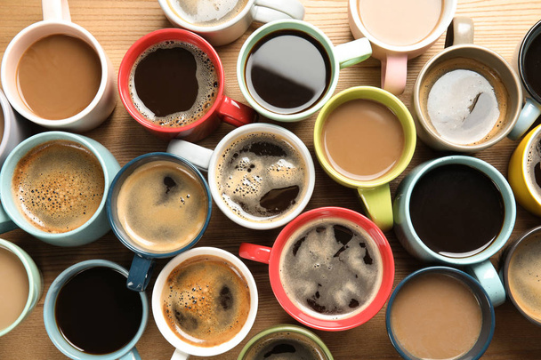 Tassen mit frischem aromatischen Kaffee auf Holzhintergrund, Draufsicht. Lebensmittelfotografie - Foto, Bild