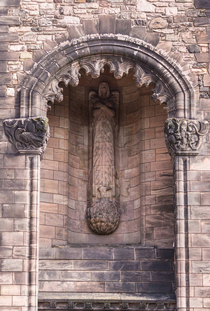 Edinburgh, Scotland, Wielka Brytania - 14 czerwca 2012 r.: Nisza z rzeźbą anioła jak kobieta na wieży wejście do brązowego kamienia Scottish National War Memorial na zamku. Elewacji południowej elewacji. - Zdjęcie, obraz