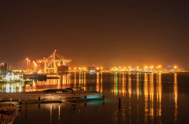 Brilho e brilho de luzes do porto de Tauranga Harbour Bridge e rodeia iluminar céu noturno e porto
 - Foto, Imagem