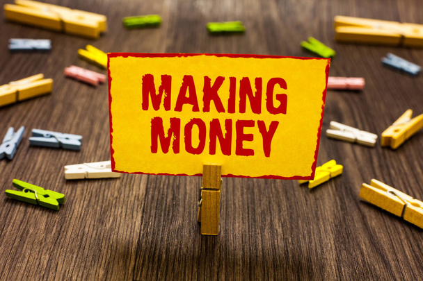 Text sign showing Making Money. Conceptual photo Giving the opportunity to make a profit Earn financial support Clothespin holding yellow paper note several clothespins wooden floor. - Photo, Image