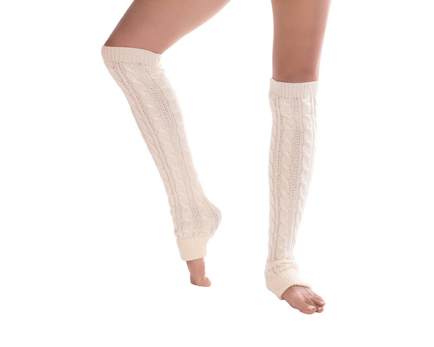 Female slim legs in white leg warmers. White pedicure. Close up, isolated on white background - Foto, afbeelding