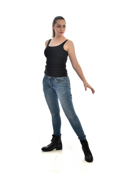 retrato de comprimento total da menina morena vestindo preto único e jeans. postura de pé. isolado em fundo estúdio branco
. - Foto, Imagem