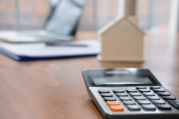 calculator & house model at real estate office. mortgage and property concept - Foto, Imagen