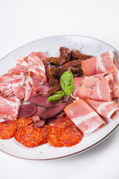 antipasti with ham,sausage and fresh basil isolated on white - Foto, Bild
