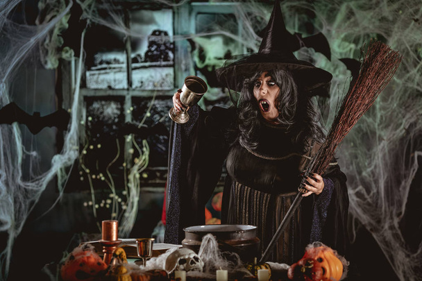 Ведьма с ужасным лицом в жуткой обстановке готовит волшебное зелье
  - Фото, изображение