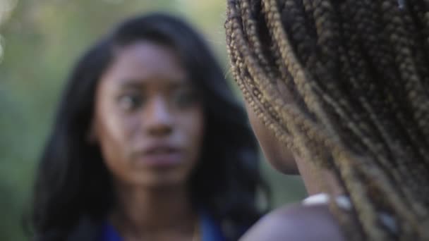 Zeitlupe Rack Fokusaufnahme einer afrikanisch-amerikanischen Krankenschwester in Peelings im Gespräch mit einem Patienten - Filmmaterial, Video