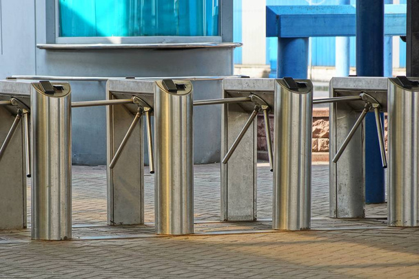 una fila di tornelli metallici sul marciapiede della stazione
 - Foto, immagini