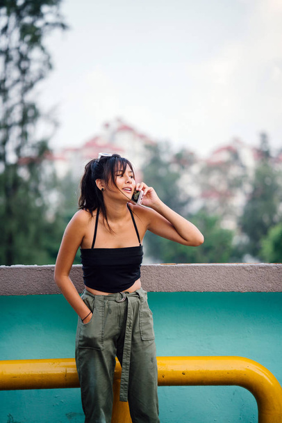 Young asian woman in casual clothes talking on smartphone  - Fotó, kép