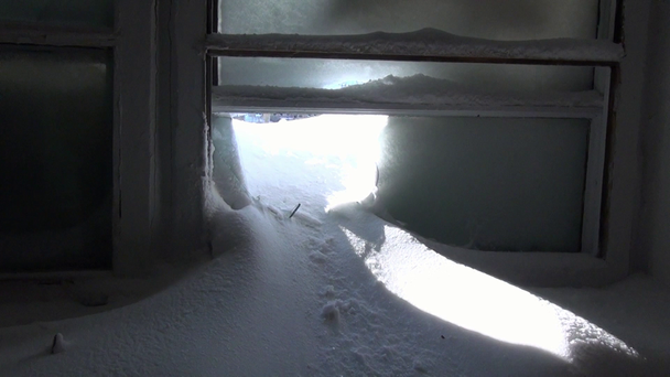 Schnee im zerbrochenen Fenster eines verlassenen Hauses in einer verlassenen Stadt. - Filmmaterial, Video