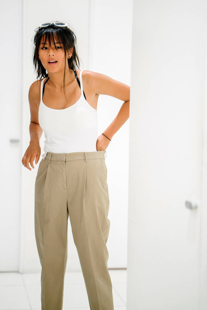 Young asian woman trying new pants in shopping mall - Foto, imagen