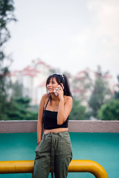 Young asian woman in casual clothes talking on smartphone  - Foto, afbeelding