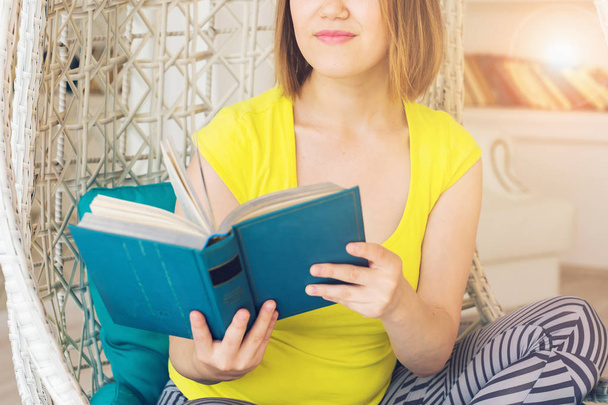 Close up van een jonge vrouw lezen van een boek thuis - Foto, afbeelding