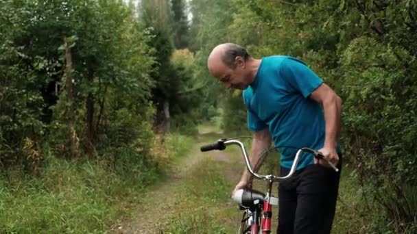 Vezető kaukázusi Férfi próbál kerékpározni kék póló. - Felvétel, videó