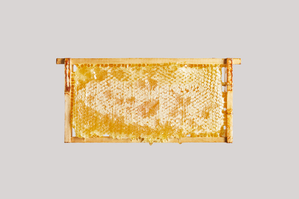 close up view of sweet beeswax on grey background - Foto, Imagem