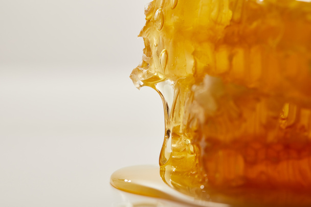 close up view of sweet beeswax and honey on white background - Zdjęcie, obraz