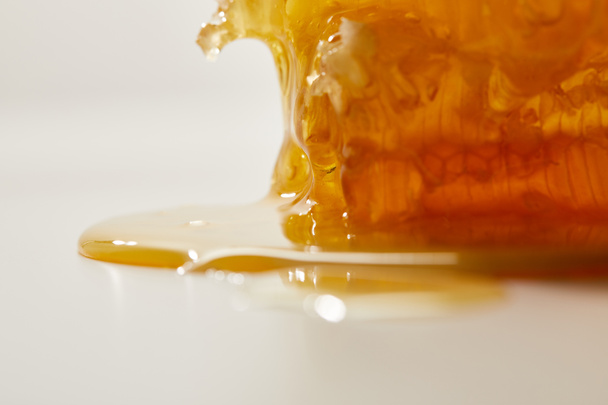 close up view of sweet beeswax and honey on white background - Fotoğraf, Görsel