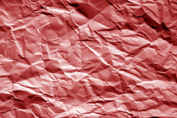 Crumpled sheet of paper in red tone. Abstract background and texture for design. - Foto, afbeelding
