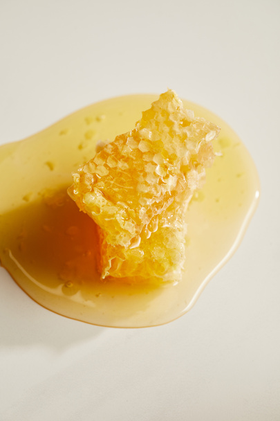 close up view of sweet beeswax and honey on white tabletop - Foto, immagini