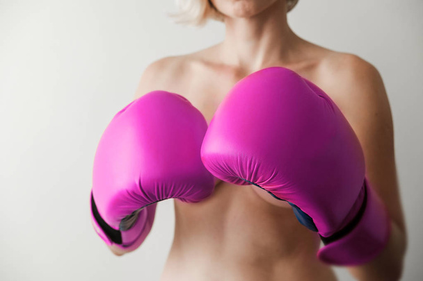 裸の女性は、裸の胸がピンクのボクシング グローブをカバーしています。セクシーで強い。フェミニズム、ガールパワー、戦い, ジェンダー, 女性の権利概念  - 写真・画像